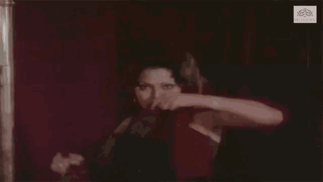 a woman in a red dress is dancing in front of a red curtain with a watermark that says snl studios