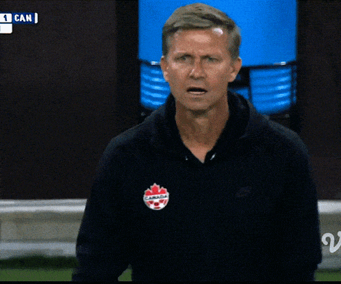 a man wearing a black jacket that says canada on the front