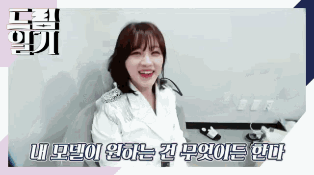 a woman in a white jacket is smiling in a room with korean writing on the bottom