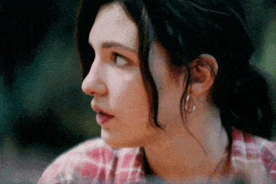 a woman wearing hoop earrings and a plaid shirt