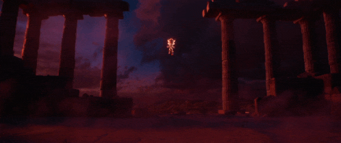 a dark room with columns and a light coming out of the pillars