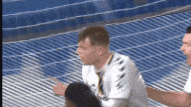 a man in a white shirt is running on a blue track