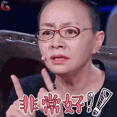 a woman wearing glasses is making a funny face and giving a thumbs up .