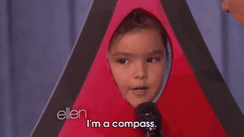 a man is standing next to a little girl in a compass costume and says " i 'm a compass "