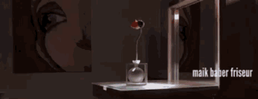 a vase of red flowers sits on a table with soap bubbles surrounding it and the words maik bader friseur