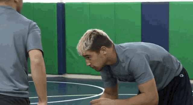 a man wearing a champion shirt is kneeling down