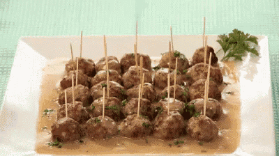 a white plate topped with meatballs on sticks