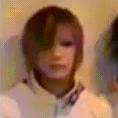 a blurry picture of a person with short hair and a white shirt