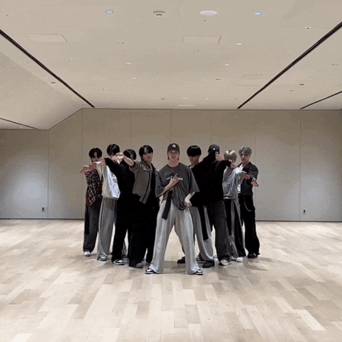a group of young men are standing on a wooden floor in a room