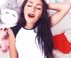 a woman wearing a totoro hat is standing in a bedroom