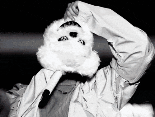 a black and white photo of a person wearing a rabbit mask