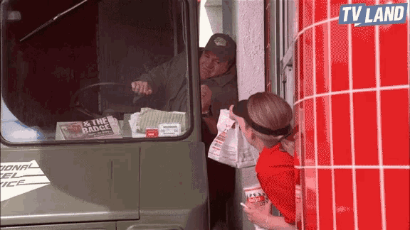 a man is getting food from a truck with a tv land sign above it