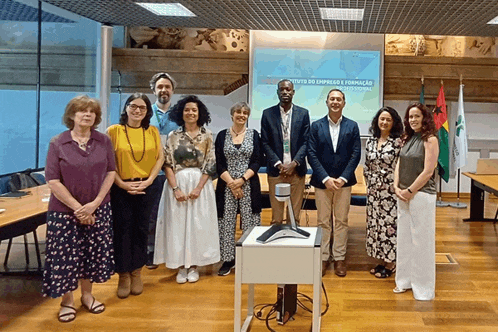 a group of people standing in front of a projector screen that says instituto de empregos e formacion
