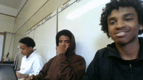 three young men are sitting in front of a white board that says thursday on it