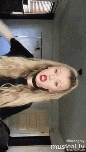 a girl with long blonde hair and red lips is making a funny face ..