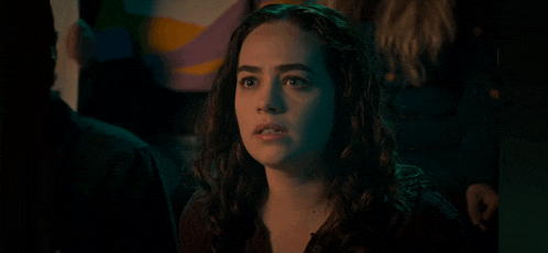 a woman with curly hair is looking at the camera