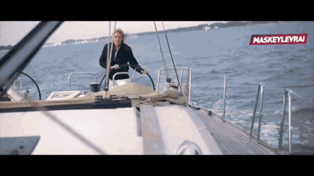 a woman steering a sailboat with maskeylevrai written on the bottom right