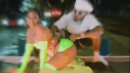 a man is sitting on a woman 's lap while she is dancing .