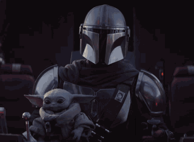 a man in armor is holding a baby