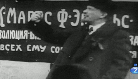 a man stands in front of a sign that says " маркс " on it