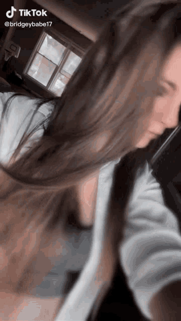 a tiktok video of a woman with long hair is being shared