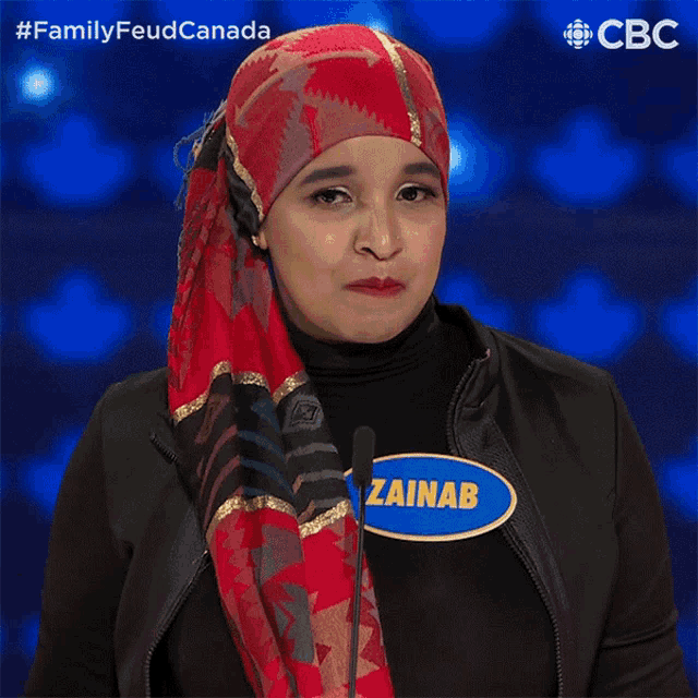 a woman wearing a scarf and a name tag that says " zainab "