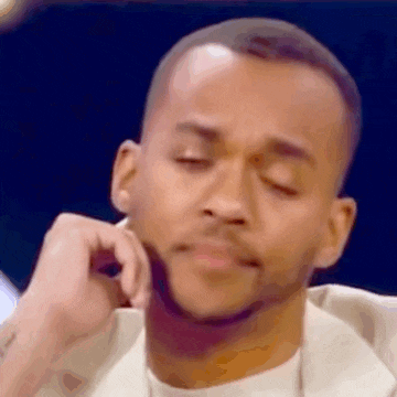 a close up of a man with his eyes closed and his hand on his face .