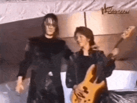 a man and a woman are standing next to each other and one is holding a guitar .