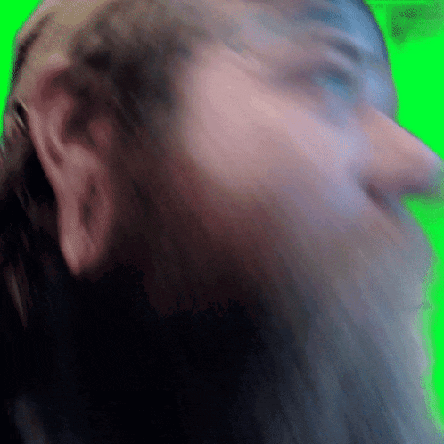 a blurry image of a man 's face with a green background