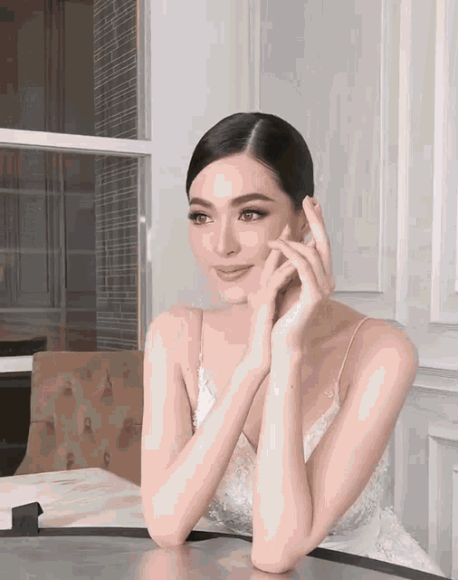 a woman sitting at a table with her hands on her face