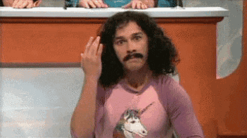 a man with long hair and a mustache wearing a pink shirt with a unicorn on it is giving the middle finger .