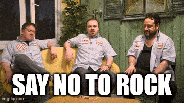 three men are sitting on a yellow couch with the words say no to rock behind them