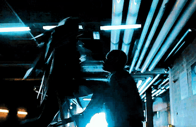 a man is standing in a dark room with pipes and a sign that says ' x ' on it
