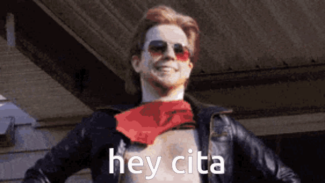a man wearing sunglasses and a red bandana is smiling and saying hey cita .