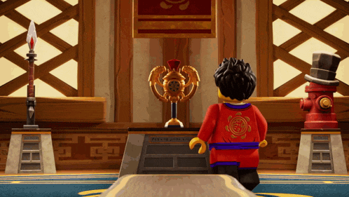 a lego figure stands in front of a trophy that says ' ninjago ' on the back