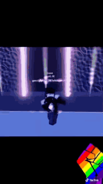 a video of a person in a video game with a rainbow cube in the corner