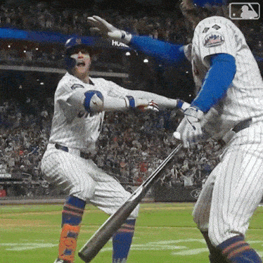 two mets baseball players are playing a game and one of them is holding a bat