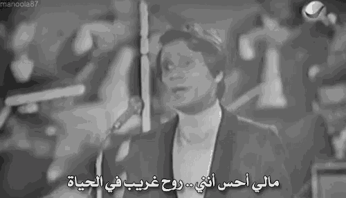 a black and white photo of a man singing into a microphone with arabic writing on it .