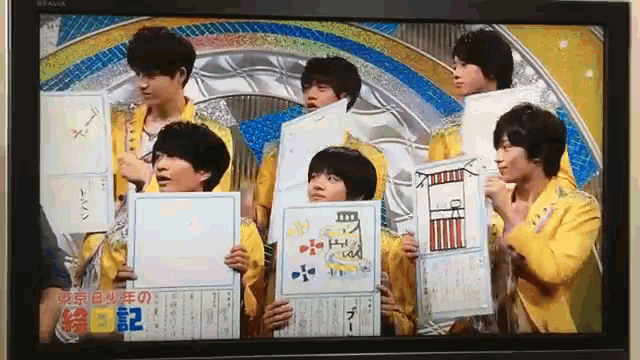 a group of young men are holding up signs with the number 2 on it