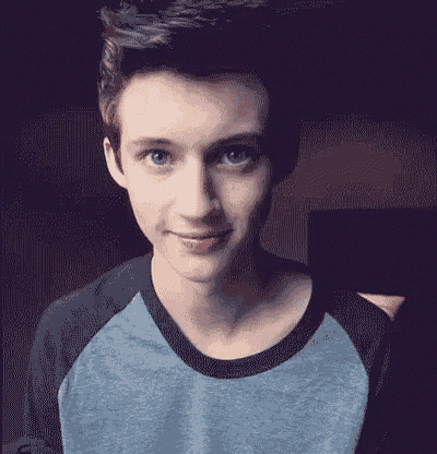 a young man with blue eyes is smiling for the camera .