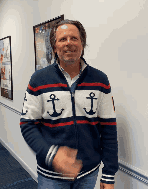 a man wearing a sweater that has anchors on it