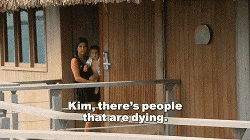 a woman holding a child on a balcony with the words kim there 's people that are dying