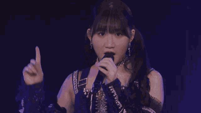 a girl is singing into a microphone on a stage .