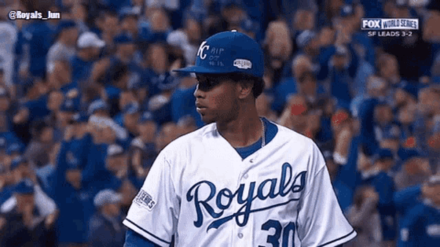 a baseball player wearing a royals jersey is standing in front of a crowd