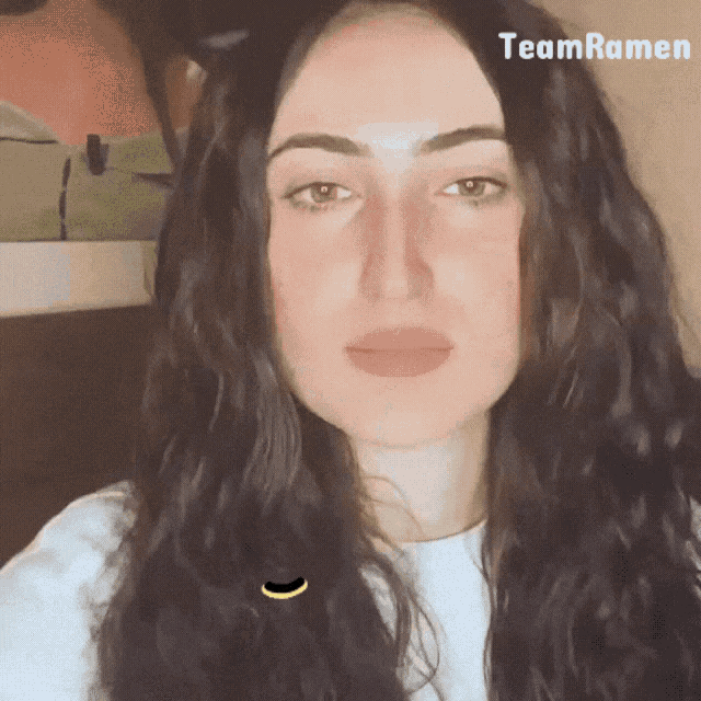 a close up of a woman 's face with the word team ramen behind her