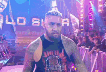 a man wearing a tank top that says ' eminem ' on it is walking on a stage .