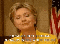 hillary clinton is smiling in front of an american flag while donald trump is in the white house .