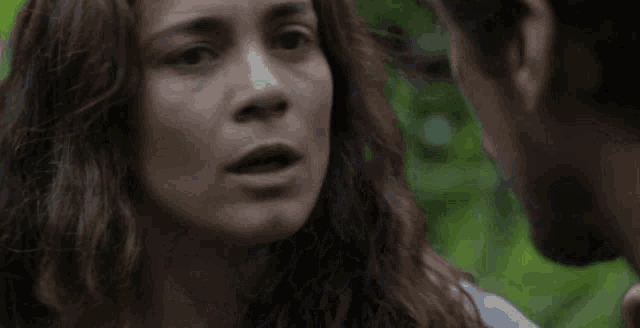 a man and a woman are looking at each other and the woman is looking at the camera .