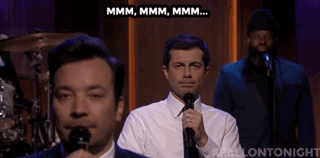 a man singing into a microphone with a caption that says " mmmm mmmm mmmm "