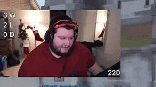 a man with a beard wearing headphones is playing a video game in a living room .